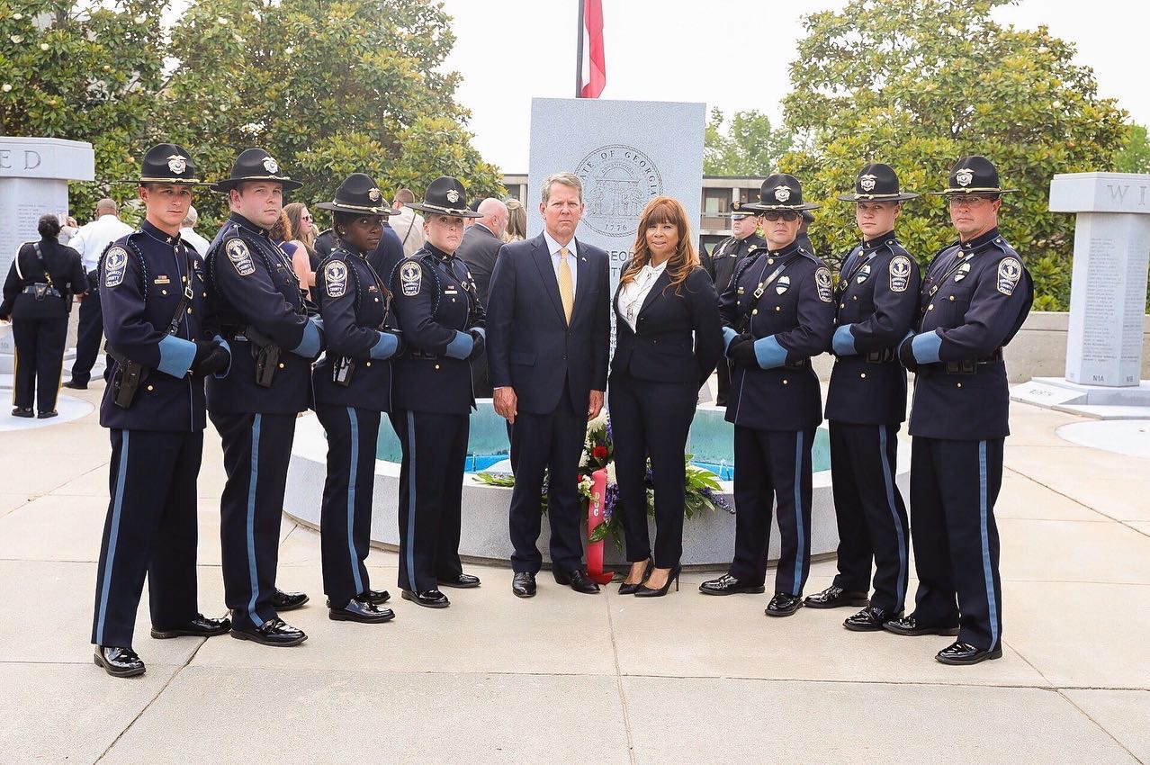 Officer Ashley Wilson, to the left of Gov. Kemp, during the memorial that honored her fallen colleague.