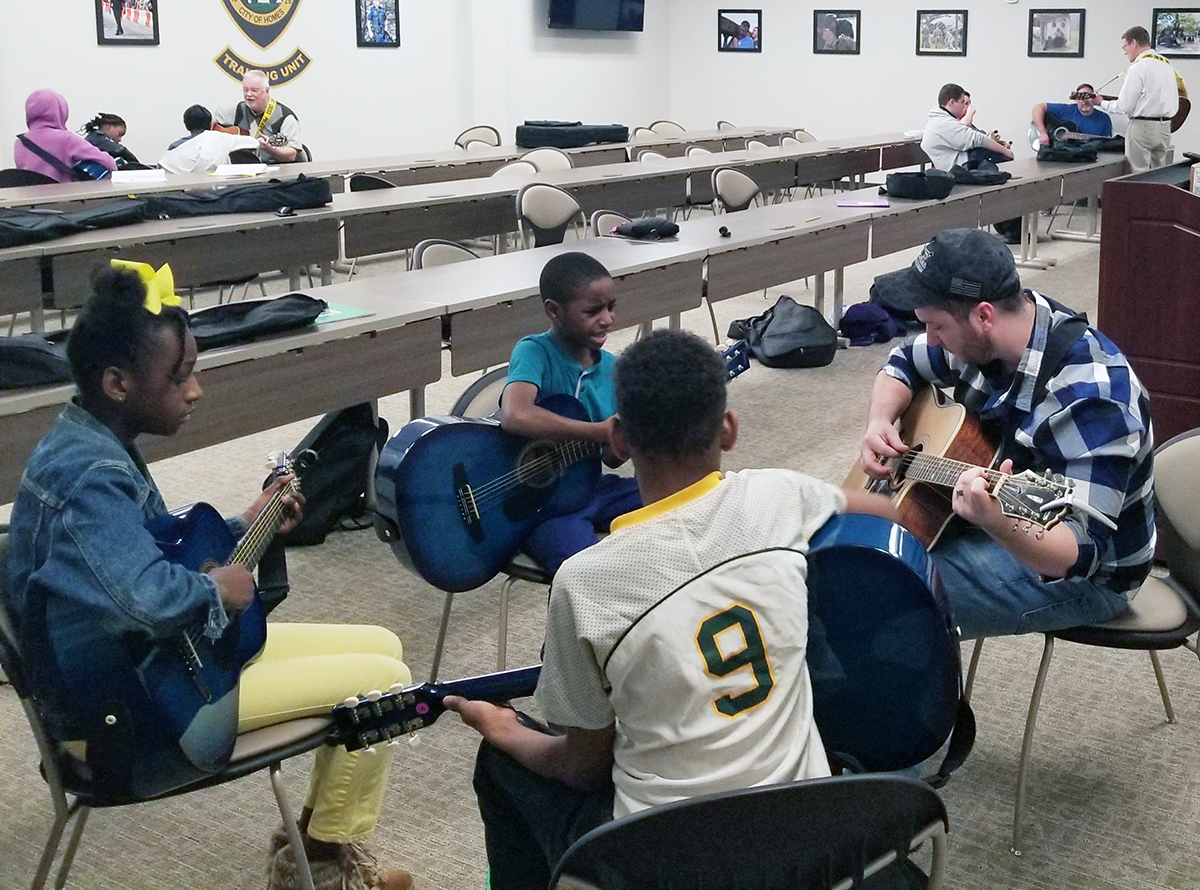 Newnan "Guitars Not Guns" students and instructors practicing at the city's police department.